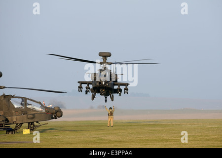 Britische Armee AH-64 zur Verbreitung am Flugplatz Lager, Netheravon nach Einsatzvorbereitenden Ausbildung Sortie auf Salisbury Plain gemarshallt. Stockfoto