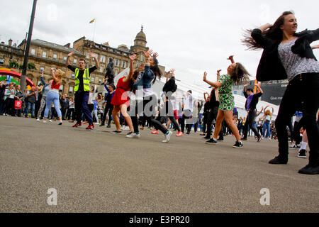 Glasgow, Schottland. 27. Juni 2014. Ein Flashmob der 100 Tänzer kündigt die Eröffnung der offiziellen Spiele waren Superstore von CEO David Grevemberg Credit: ALAN OLIVER/Alamy Live News Stockfoto