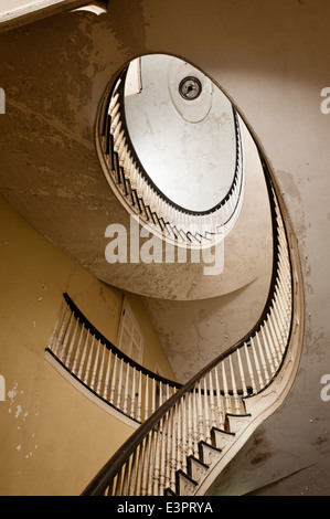 Blick hinauf eine elliptische Treppe mit peeling Deckenfarbe Stockfoto