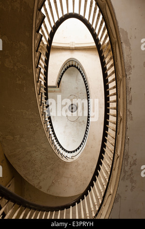 Blick hinauf eine elliptische Treppe mit peeling Deckenfarbe Stockfoto