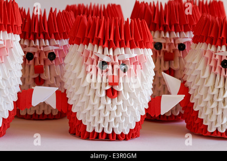 Reihen von origami Santa Claus Weihnachtsmann Dekorationen auf weißem Hintergrund Stockfoto