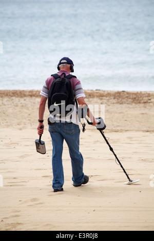 Mann mit Metalldetektor Kämmen nach dem verlorenen Schatz am Strand von Bournemouth im Juni Stockfoto