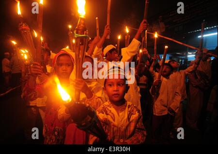 (140627)--JAKARTA, 27. Juni 2014 (Xinhua)--indonesische muslimische Kinder halten Bambus Fackeln während einer Parade feiern die bevorstehende heiligen Fastenmonats Ramadan in Jakarta, Indonesien, 27. Juni 2014. Indonesische Regierung angekündigt, dass Ramadan am 29. Juni 2014 beginnen würde. (Xinhua/Zulkarnain) (Djj) Stockfoto