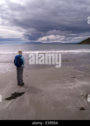 Einsamer Wanderer auf Camasunary Strand auf der Insel Skye, mit Blick über den Loch Scavaig auf die Insel Rum & Cloud Plume, Schottland, Großbritannien. Stockfoto