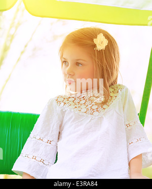 Porträt der entzückende kleine Mädchen auf einer Schaukel im Freien an sonnigen Tagen, Aktivitäten im Sommer Reiten Spaß im Kindergarten Stockfoto