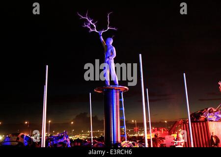 Glastonbury Festival. Glastonbury, Somerset, UK. 28. Juni 2014. Arcadia Künstler verkleidet in einem Kettenhemd Anzug für Schutz Entladungen Hochspannung Strom als Massen Partei auf in den frühen Stunden des morgens. Bildnachweis: Tom Corban/Alamy Live-Nachrichten Stockfoto