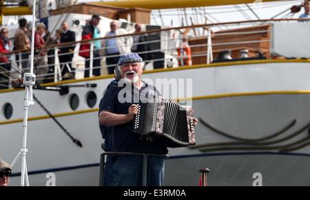 Kiel, Deutschland. 28. Juni 2014. Ein Besucher spielt auf dem Akkordeon während der traditionellen Windjammer Parade während der Kieler Woche in Kiel, Deutschland, 28. Juni 2014. Foto: Carsten Rehder/Dpa/Alamy Live News Stockfoto