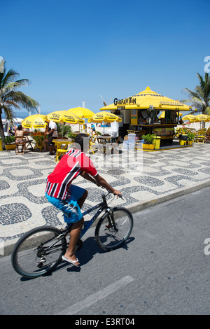 RIO DE JANEIRO, Brasilien - 11. Februar 2014: Ein brasilianische Mann fährt ein Fahrrad auf dem Radweg Strandpromenade Avenida Vieira Souto Stockfoto