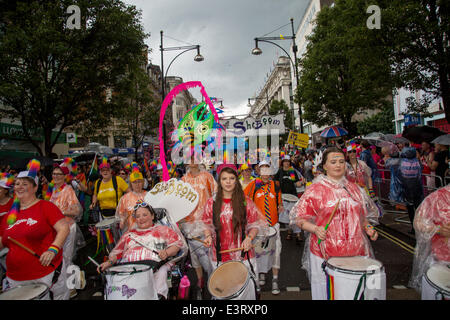 Massen marschieren auf Oxford Straße in sehr nassen und feuchten Bedingungen, einige spielen Trommeln und andere im Rollstuhl für den Beginn der Gay-Pride. Stolz zog Tausende Besucher trotz der kräftigen Schauern. Stockfoto