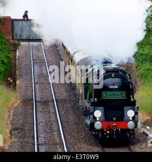 Reigate, Surrey. Samstag, 28. Juni 2014. Beobachtet von einem Zuschauer auf einer Brücke, die Belmond British Pullman VS Orient Express Steam Locomotive BR (S) Handelsmarine Clan Line Klasse 4-6-2 Nr. 35028 rast durch die Surrey Hills, 1504hrs Samstag, 28. Juni 2014 auf dem Weg nach London Victoria. Credit: Foto von Lindsay Constable / Alamy Live News Stockfoto