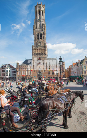 Brügge, Belgien - 12. Juni 2014: Die Beförderung auf dem Grote Markt und Belfort van Brugge im Hintergrund. Stockfoto