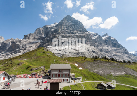 Grosse Scheidegg, Grindelwald, Berner Oberland, Schweiz: Blick auf Wetterhorn mit Restaurant und Mountain Biker an einem sonnigen Tag Stockfoto