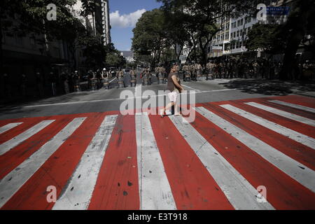 Belo Horizonte, Brasilien. 28. Juni 2014. Eine Frau geht vorbei an Polizei während einer Protestaktion gegen FIFA World Cup in Sao Paulo, Brasilien, am 28. Juni 2014. Bildnachweis: Mauricio Valenzuela/Xinhua/Alamy Live-Nachrichten Stockfoto