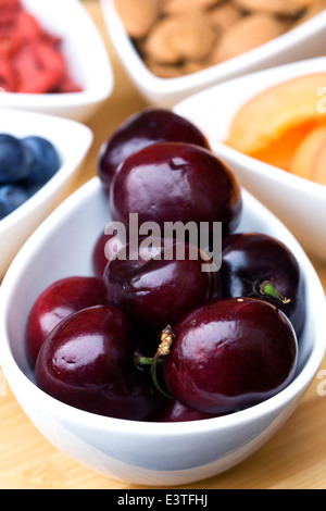 Fresh cherries in a white bowl, a selection of healthy snacks. Stockfoto