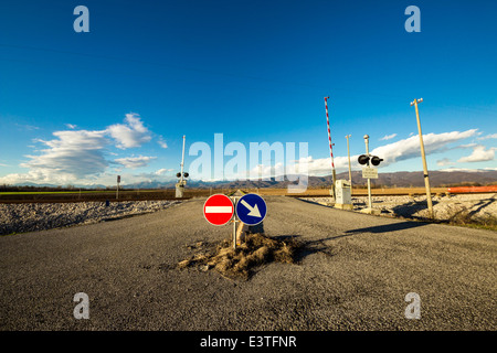 eine isolierte Bahnübergang im Plan von Friaul-Julisch-Venetien. Berge im Hintergrund. Stockfoto