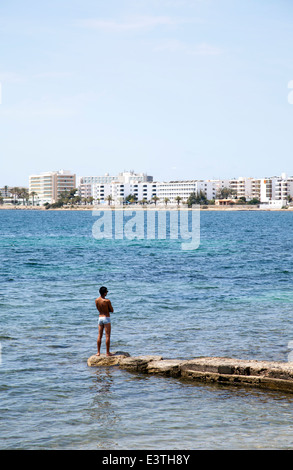 Mann auf der Buhne in Figueretas Strand auf Ibiza - Spanien Stockfoto