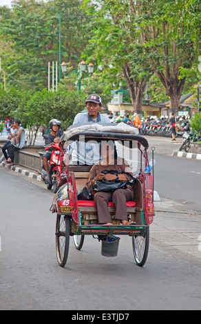 YOGYAKARTA - AUGUST 03: Traditionelle Rikscha Transport auf Straßen von Yogyakarta, Java, Indonesien am August 03, 2010. Fahrrad Rikscha bleibt beliebtes Verkehrsmittel in vielen indonesischen Städten. Stockfoto