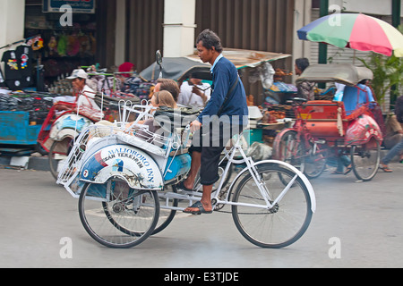 YOGYAKARTA - AUGUST 03: Traditionelle Rikscha Transport auf Straßen von Yogyakarta, Java, Indonesien am August 03, 2010. Fahrrad Rikscha bleibt beliebtes Verkehrsmittel in vielen indonesischen Städten. Stockfoto