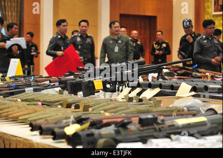 Bangkok, Thailand. 29. Juni 2014. Thailändische Polizisten untersuchen Waffen beschlagnahmt bei einer Razzia vom 22. Mai bis Juni 25 auf einer Pressekonferenz in Bangkok, Thailand, 29. Juni 2014. Seit dem Putsch am 22. Mai führte das Militär ein Durchgreifen auf Verbrechen im Rahmen welcher Befehlshaber der Armee General Prayuth Chan-Ocha als eine Moral-Reinigung für die thailändische Gesellschaft beschrieben. © Rachen Sageamsak/Xinhua/Alamy Live-Nachrichten Stockfoto