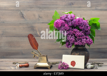 Stillleben mit lila Blüten und antike Accessoires. Retro-Stil getönten Foto Stockfoto