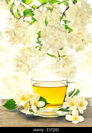 Teetasse mit Jasminblüten über die Natur verwischt Hintergrund. Vintage-Stil getönten Bild Stockfoto