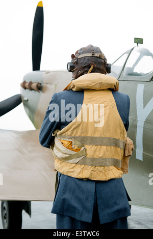 WW2 RAF Pilot, tragen seine Mae West Rettungsweste steht neben seinem Spitfire Jagdflugzeug warten zu klettern. Stockfoto