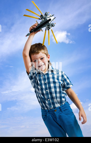 Junge mit Hubschrauber Spielzeug auf Himmelshintergrund Stockfoto