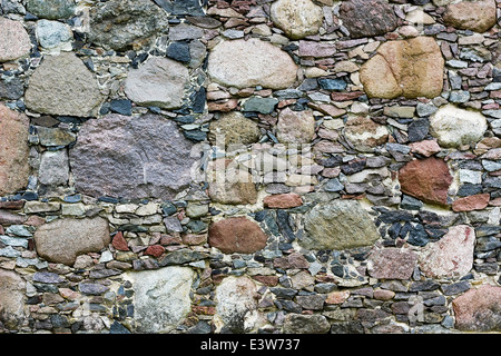 Wand aus grobem Granit kleinen und großen Steinen. Natürlichen Hintergrund Stockfoto