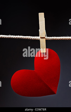 Herzförmige Karte zum Valentinstag mit textfreiraum an einem Seil mit Wäscheklammern befestigt. Romantik, Liebe und Zuneigung Konzept. Stockfoto