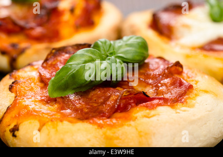 Basilikum auf eine italienische Pizza mit Chorizo Salami Wurst Stockfoto