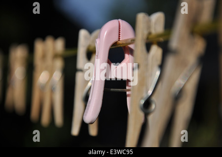 An einem sonnigen Tag hängen Holzkleider an einer Wäscheleine Stockfoto