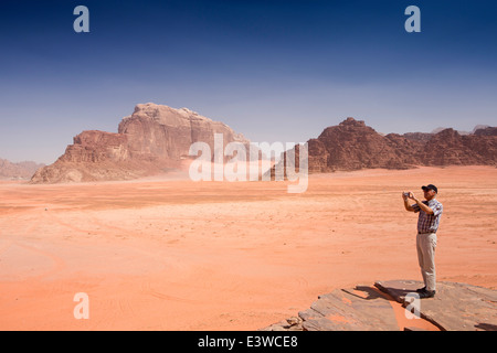 Jordan, Wadi Rum, westlichen Touristen, die roten Sanddünen von Felsvorsprung anzeigen Stockfoto