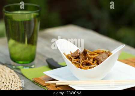 Beef Chow Mein in einer gebogenen weißen Schüssel Stockfoto