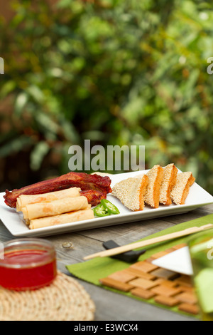 Chinesisches Essen Vorspeisen auf einer Platte draußen, wie Frühlingsrollen, Rippen und Sesam-Garnelen auf toast Stockfoto