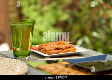 Satay Huhn am Spieß auf einem quadratischen weißen Teller außerhalb Stockfoto