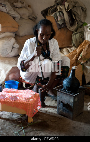 Traditionell gekleidete Frau, die Zubereitung von Kaffee zu Hause. Dies nennt man die Kaffee-Zeremonie (Äthiopien) Stockfoto