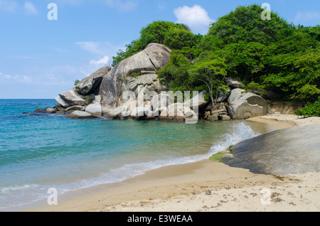 Ein Sandstrand am Meer mit Felsen und Wald. Stockfoto