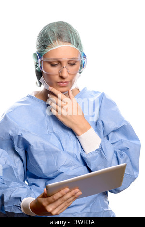 Junge Krankenschwester oder Arzt tragen blaue Scrubs funktioniert auf einem Tabletcomputer, isoliert auf weiss Stockfoto