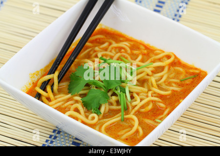 Scharfes Curry Nudelsuppe in Schüssel auf Bambusmatte Stockfoto