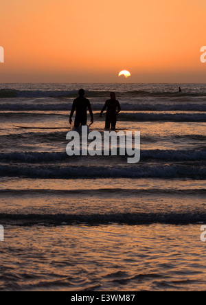 Ein paar den Sonnenuntergang während Surfen in Guernsey Stockfoto