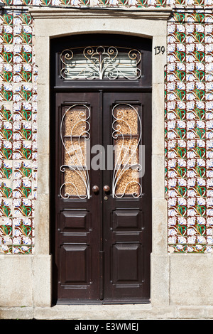 Florale Motive auf Azulejos Kacheln gemalt umgeben eine herkömmliche Tür in Ilhavo, Aveiro, Portugal Stockfoto