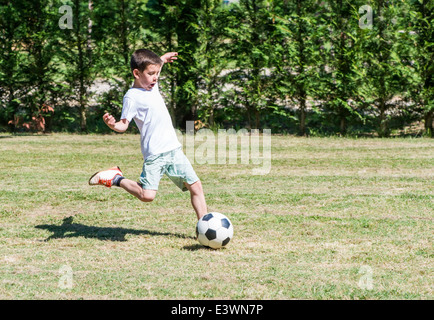 Kinder spielen Fußball in einem Stadion. Bäume auf dem Grund Stockfoto