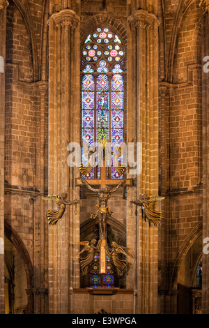 Kruzifix mit Engeln und Glasfenster des Hochaltars in der Kathedrale von Barcelona in Katalonien, Spanien. Stockfoto