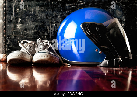 Helm und Sneaks auf Boden vor Vintage Koffer Stockfoto