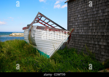 Verlassene Boot neben alten Bootshaus nahe dem Ufer des St. Lawrence River in der Gaspé-Halbinsel, Quebec, Kanada. Stockfoto