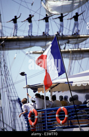 AJAXNETPHOTO. 1989, ROUEN, FRANKREICH. --VOILES DE LA LIBERTE--SEGLER MANN DER HOF ARM EIN TALL SHIP ALS EIN ZUSCHAUER BOOT VERGEHT.  FOTO: JONATHAN EASTLAND/AJAX REF: 21204 3 50 Stockfoto