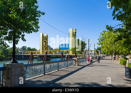 Die Uferpromenade entlang des Sacramento River mit Blick auf die Tower Bridge und Old Sacramento, Sacramento, Kalifornien, USA Stockfoto