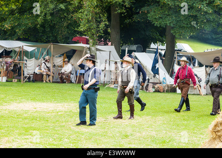 UK-Lauch, Staffordshire, England. 22. Juni 2014, einem westlichen Wochenende. Männer gekleidet als amerikanische Cowboys zu Fuß auf dem Feld. Stockfoto