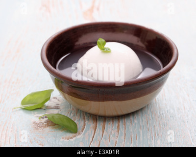 Mozzarella-Käse in Salzlake und Basilikum Blatt, horizontale Stockfoto