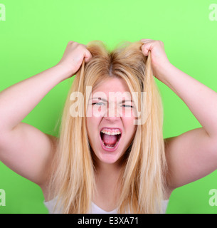 Porträt von verzweifelten blonde junge Frau, die Haare vor grünem Hintergrund Stockfoto
